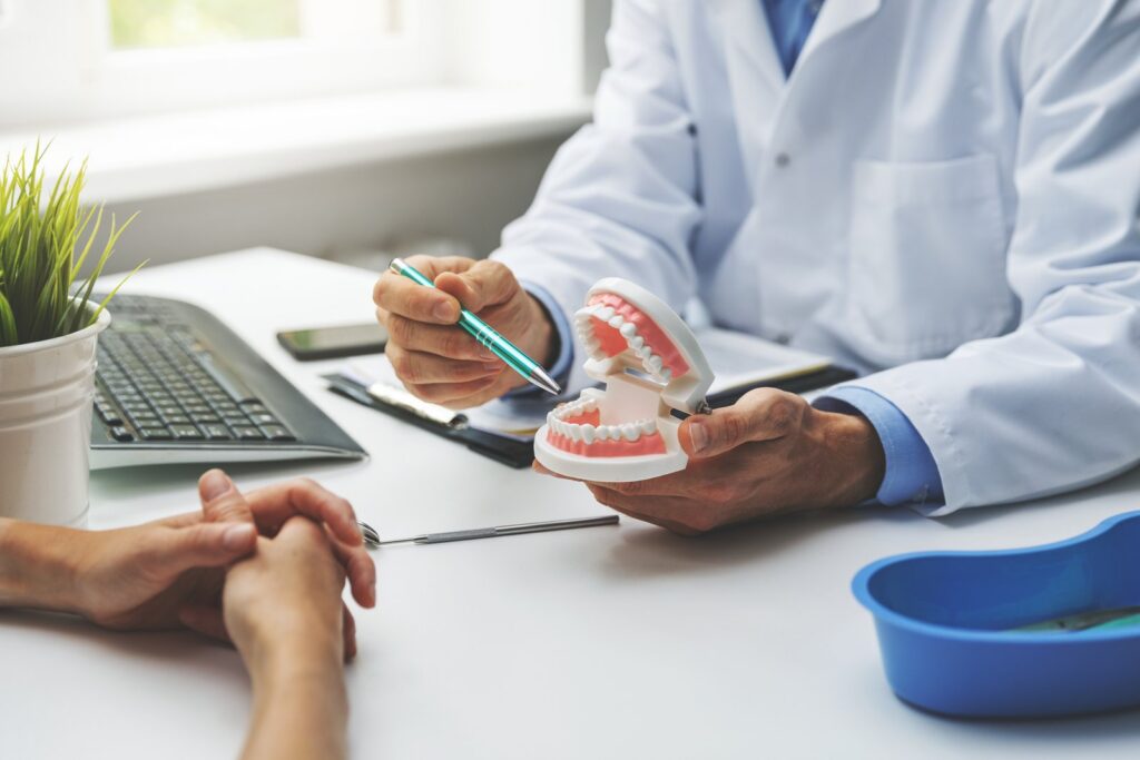 Dentist and patient discussing a planned teeth treatment in a dental clinic office